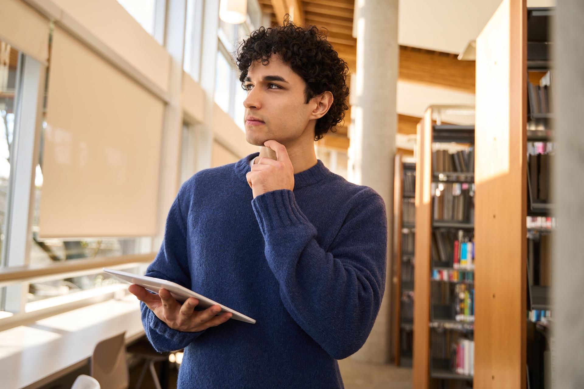 Student denkt nach in Bibliothek | Bachelorarbeiten schreiben lassen